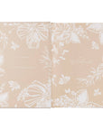 Two beige notebooks with white floral patterns on a white background