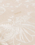 Beige fabric with white floral embroidery and 'notes' text.