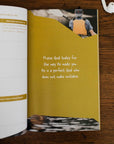 Open book with a yellow page featuring a quote and a photo of a person on a wooden surface.