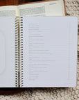 Open planner with spiral binding on a textured surface