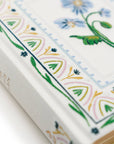 Close-up of a book with floral embroidery on a white background