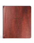Brown leather notebook with 'ONE THING I ASK' embossed on a white background