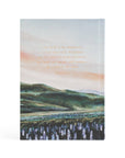 Notebook with a scenic landscape illustration and text on a white background