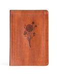 Brown leather notebook with floral embossing on a white background