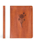 Brown leather notebook with floral design on a white background