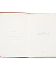 Open notebook with a brown leather cover on a white background