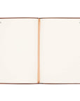 Open notebook with cream pages and brown leather binding on a white background