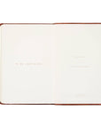 Open notebook with a brown leather cover on a white background