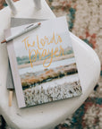 Book titled 'The Lord's Prayer' with a pen on a white chair