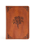 Brown leather notebook with floral design on a white background