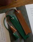 Two leather bookmarks on a book with text.