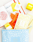 Collection of stationery items including notebooks, a book, and a box on a white background