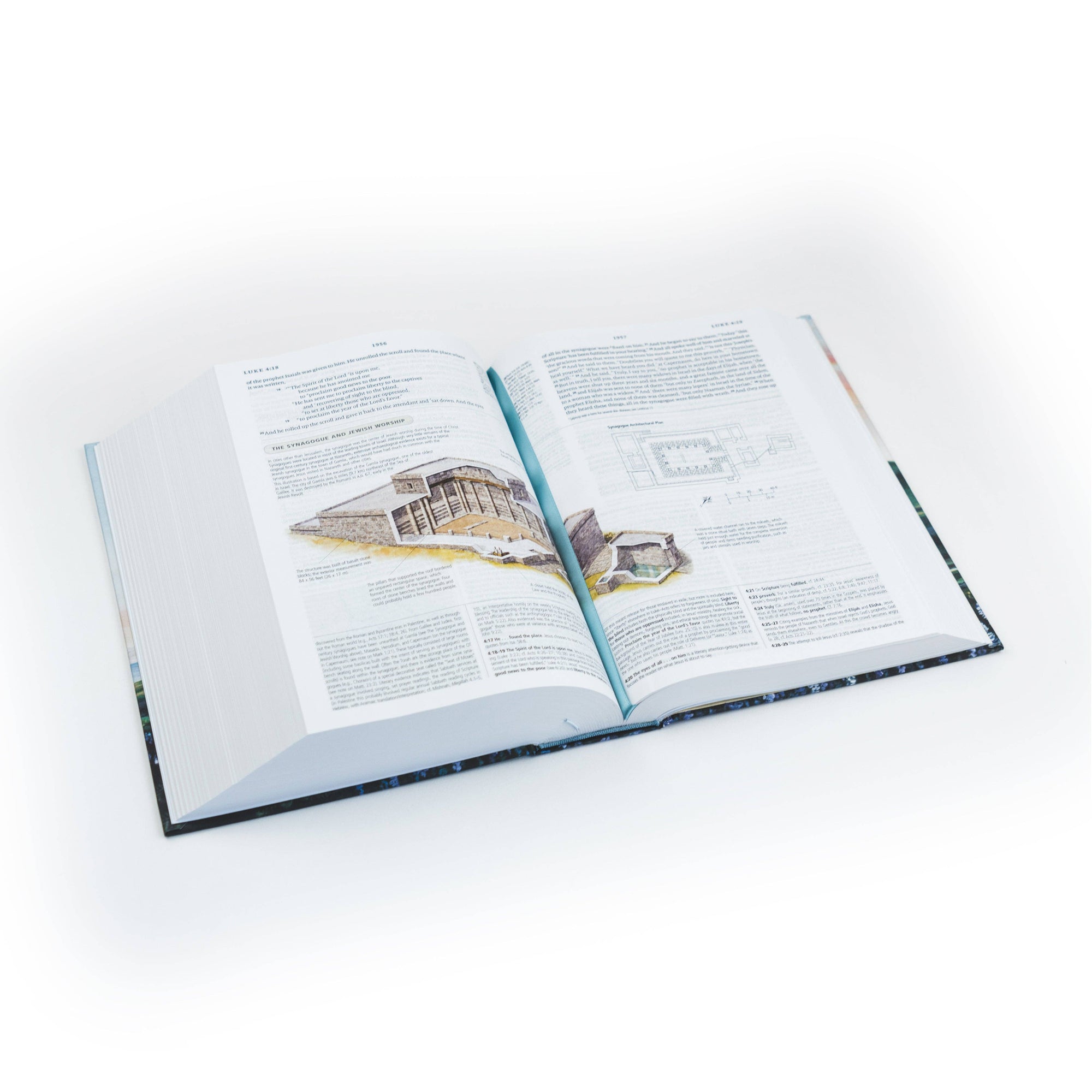 Open book on a white surface with architectural illustrations and text