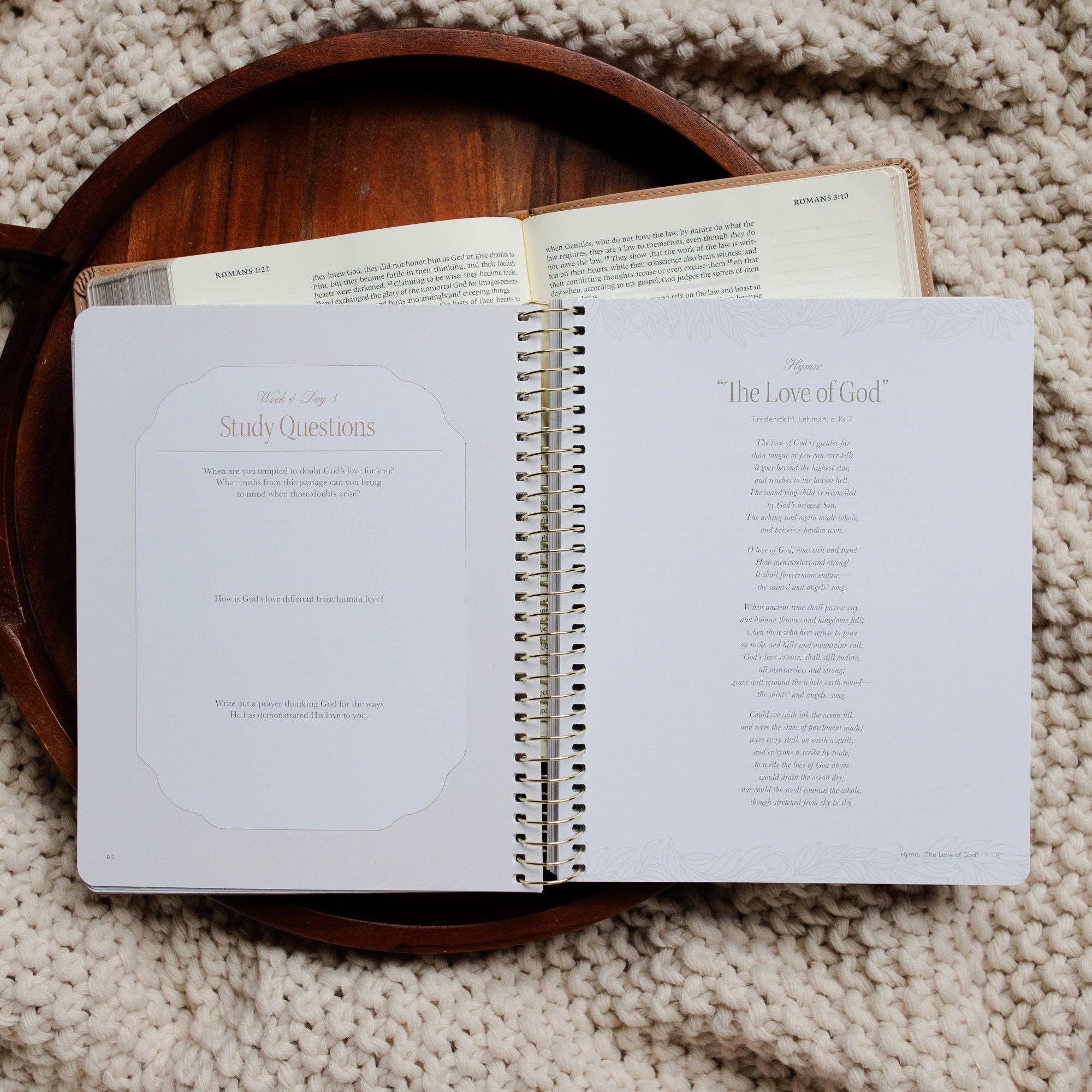 Open book on a wooden tray with a textured beige background