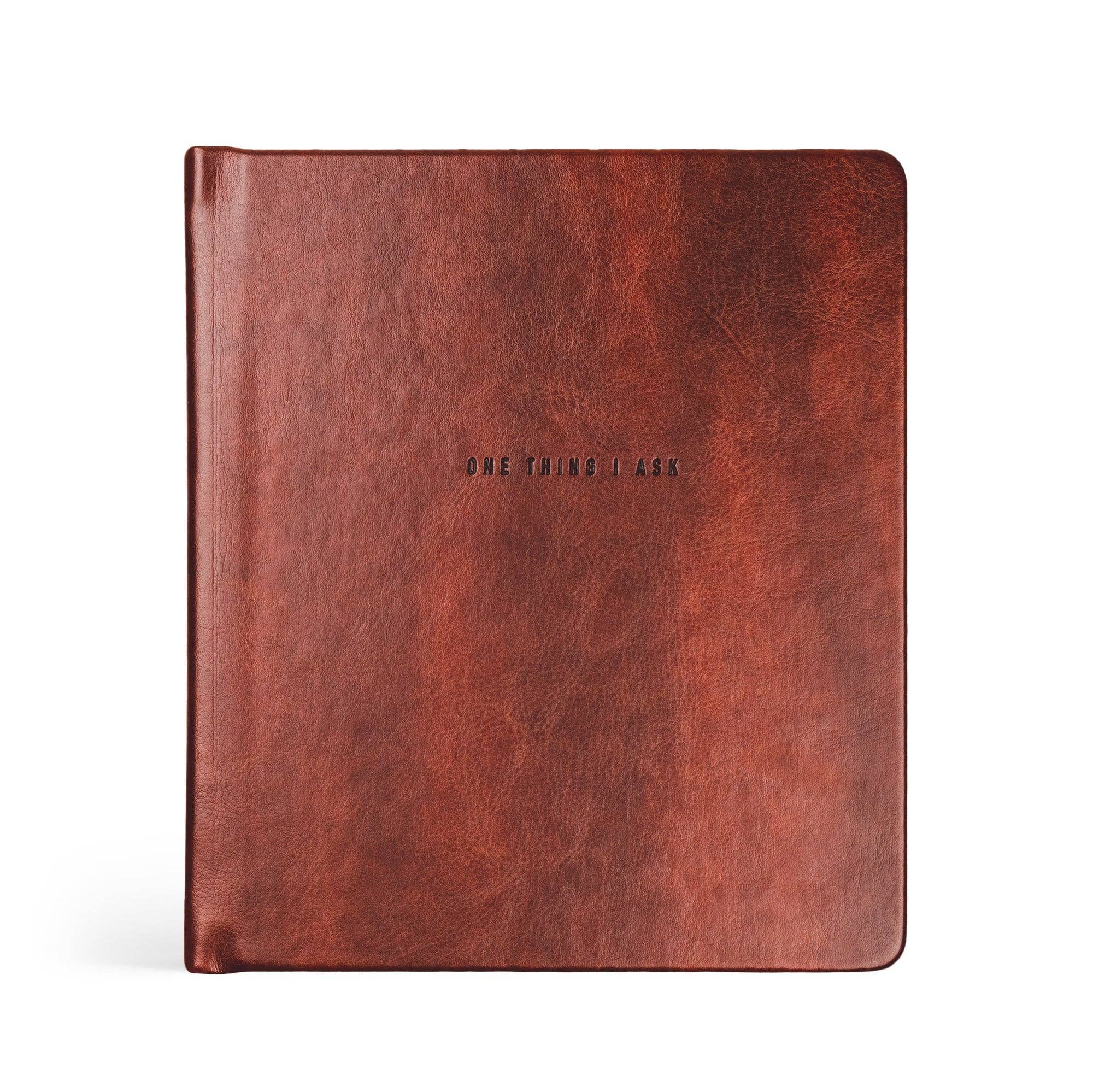 Brown leather notebook with 'ONE THING I ASK' embossed on a white background