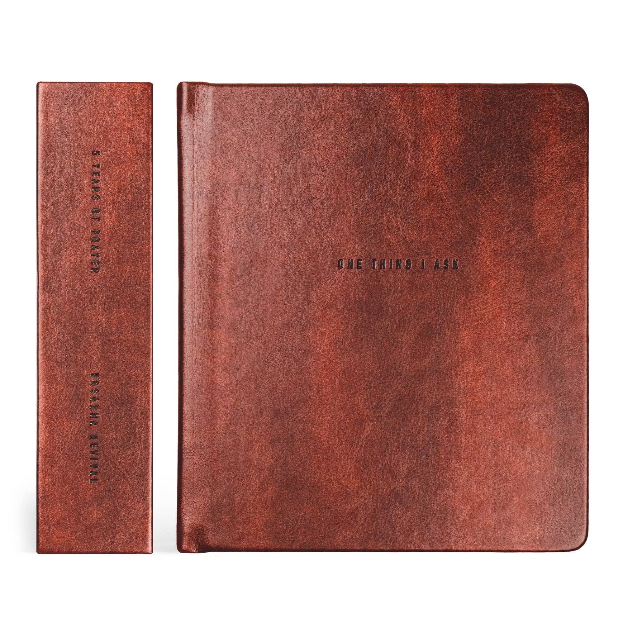 Two brown leather journals on a white background