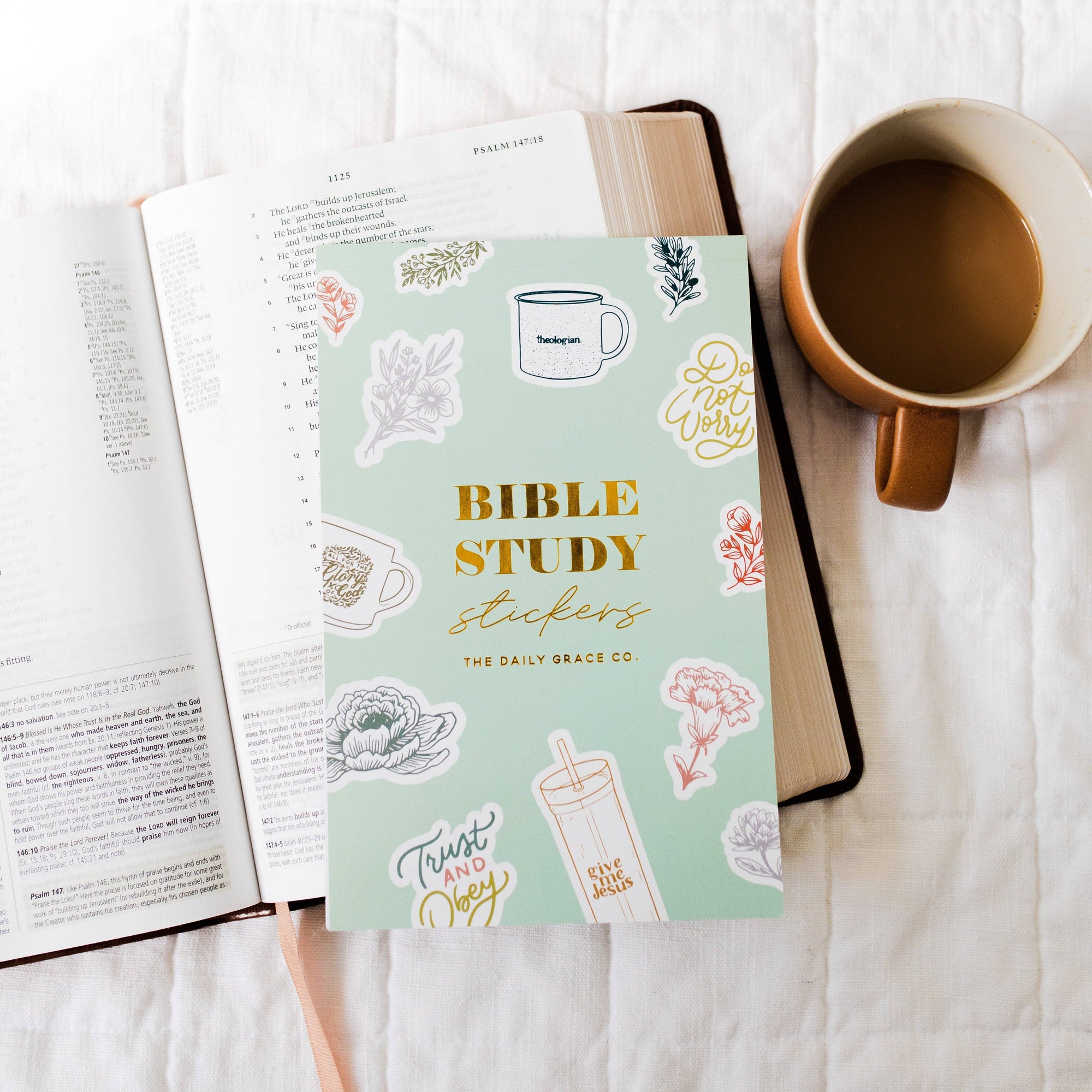Bible study stickers book with a cup of coffee on a white surface