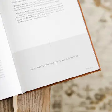 Open book with a quote on a wooden stand