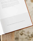 Open book with a quote on a wooden stand
