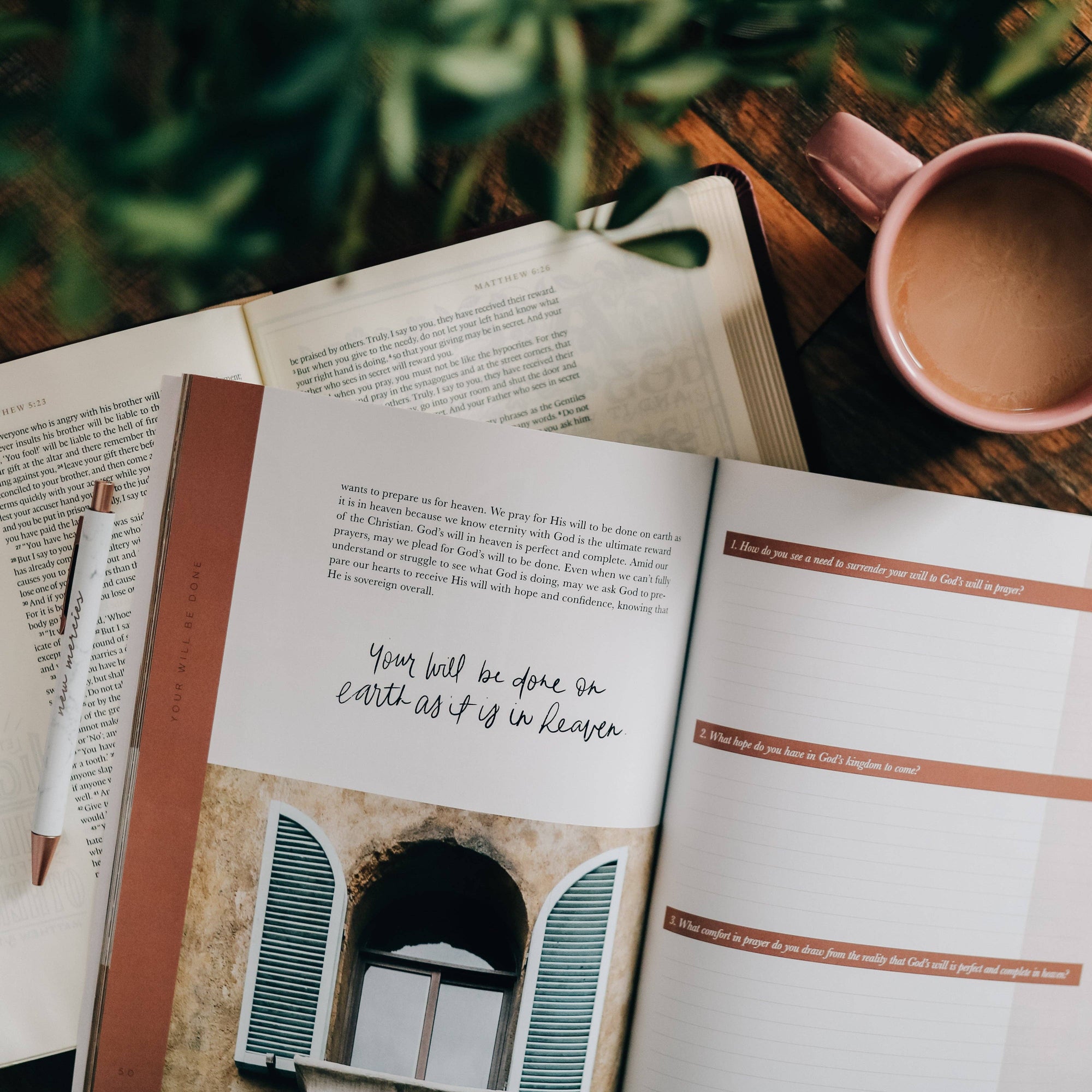 Open book with a quote on a wooden table with a cup of coffee and plant