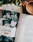 Open book with a coffee cup on a wooden surface