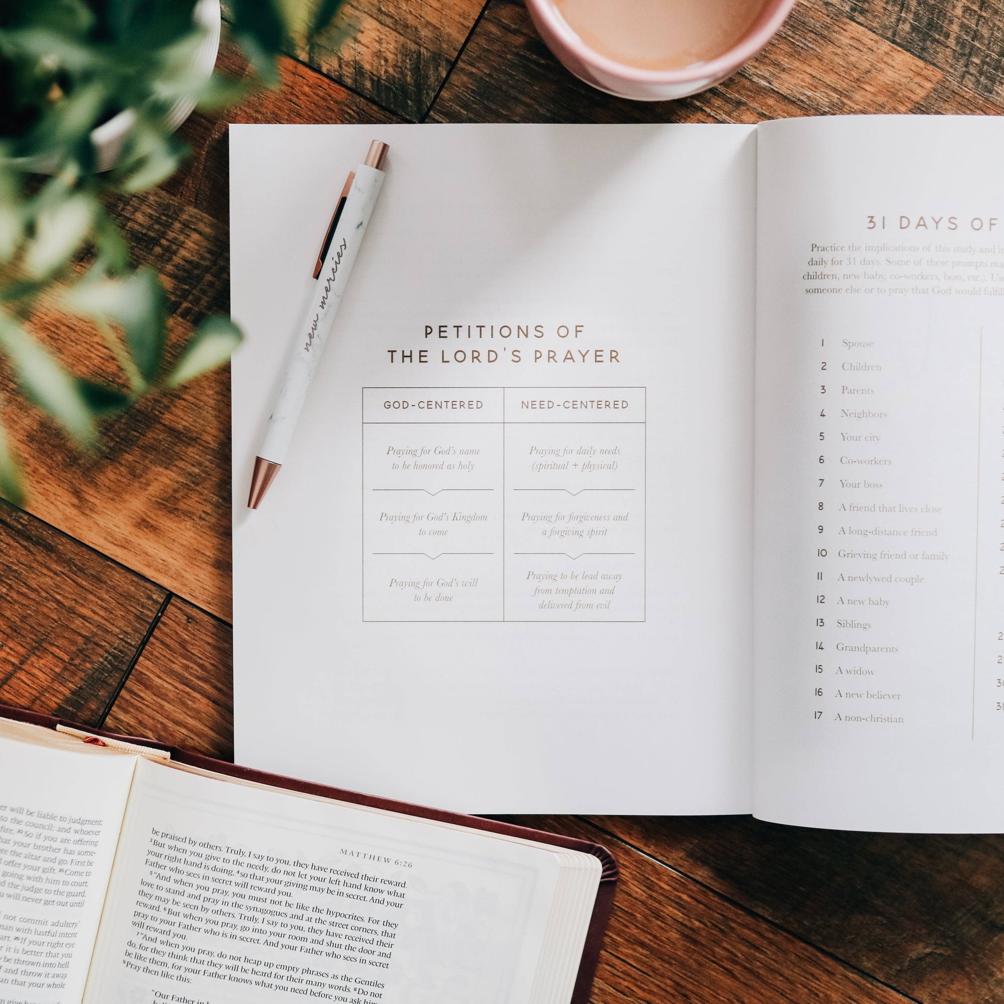 Open book on a wooden table with a pen and cup of coffee