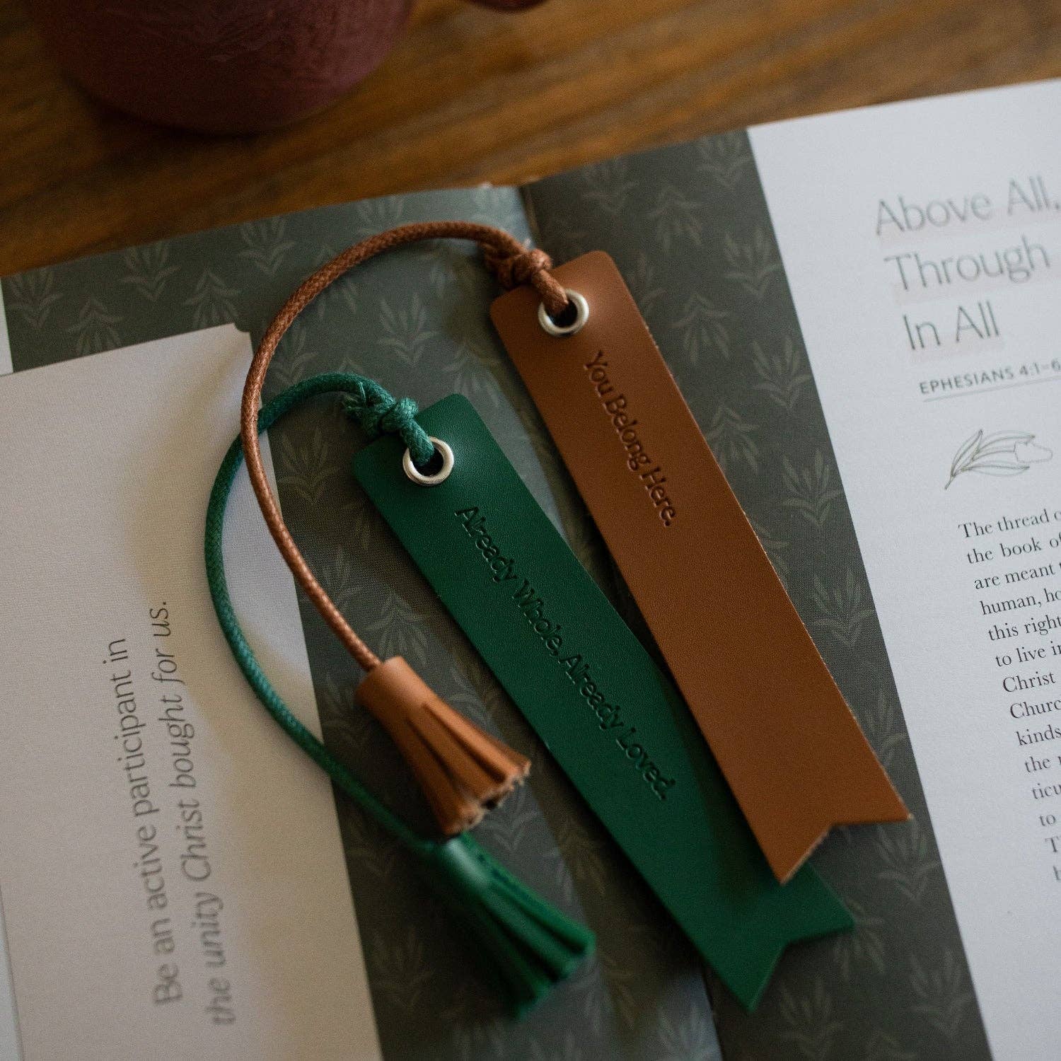 Two leather bookmarks on a book with text.