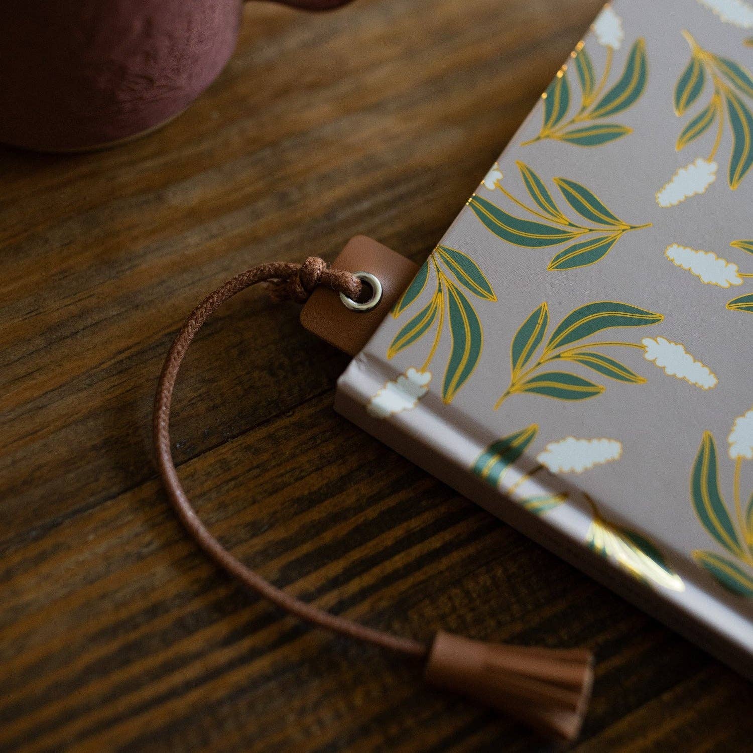 Notebook with a floral design on a wooden surface