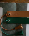 Two leather bookmarks with tassels on a book